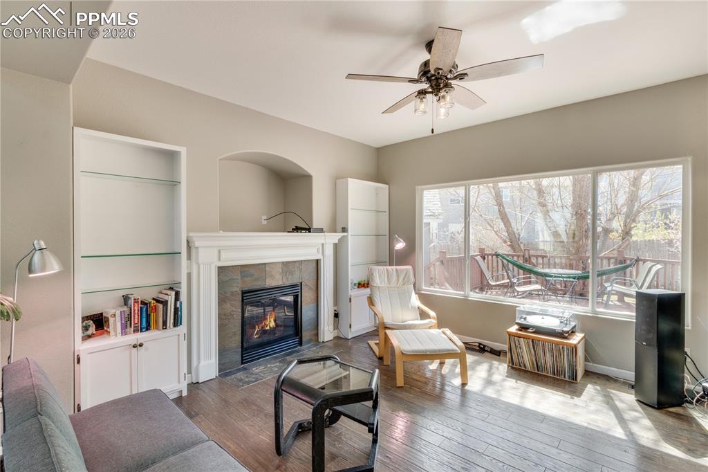 Image 8 of 39: Living room featuring built in shelves, ceiling fan, hardwood / wood-style 