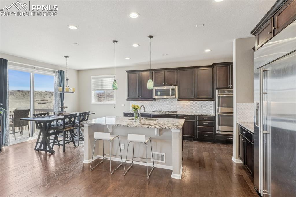Image 11 of 50: Stainless kitchen with appliances, granite counters, designer backsplash