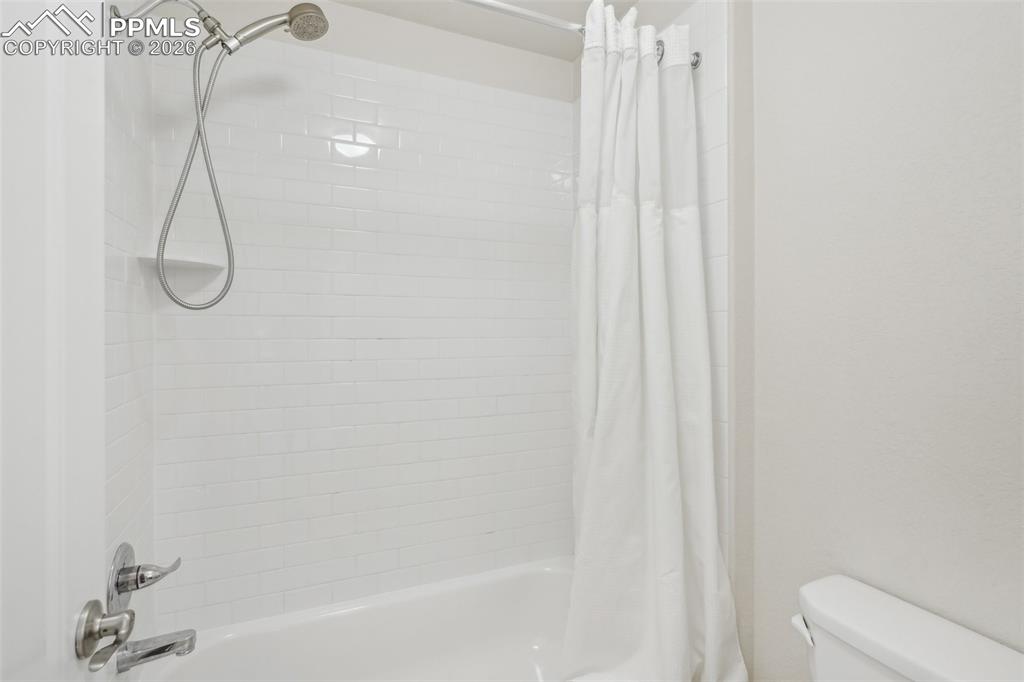 Image 34 of 50: Bathroom with shower / tub combo and toilet