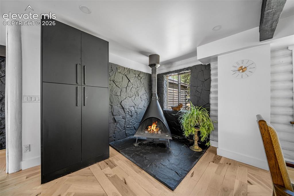 Image 12 of 50: Midcentury woodburning stove in the DR/kitchen