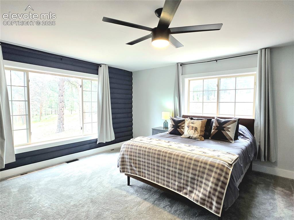 Image 18 of 50: secondary main level bedroom is spacious and has wonderful views to the fro
