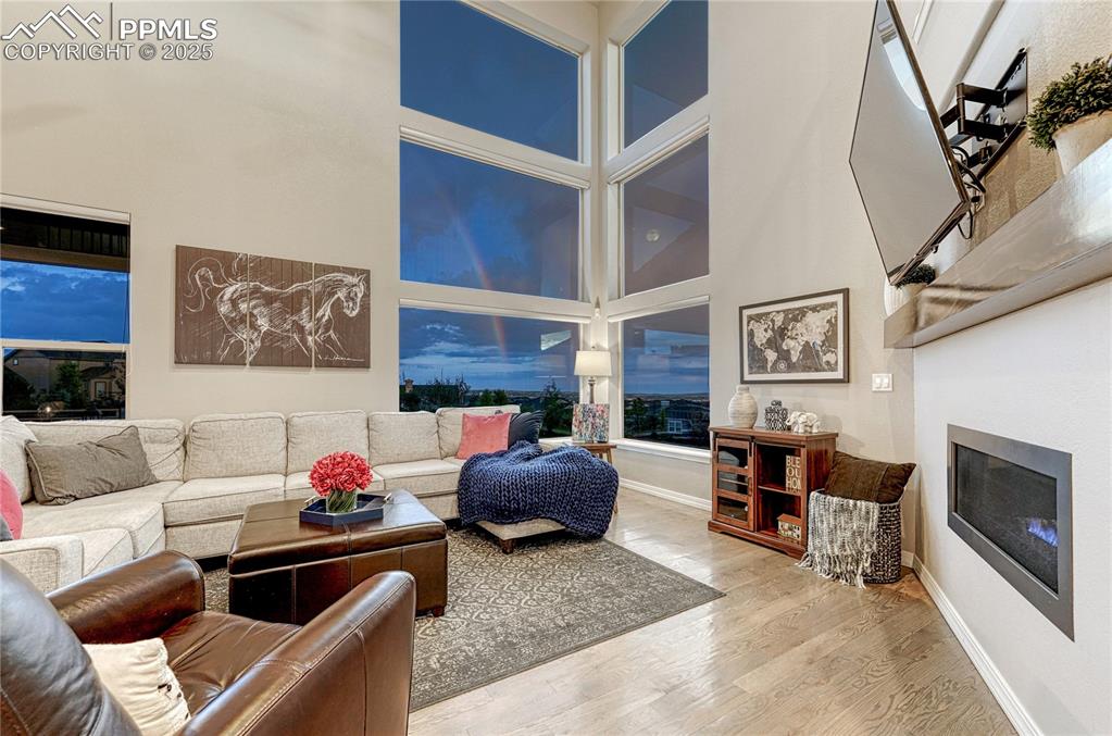 Image 2 of 48: Living area with stunning floor-to-ceiling windows and a cozy fireplace