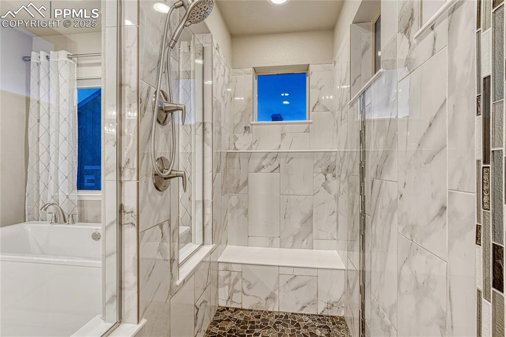 Image 21 of 48: Full bathroom featuring a marble finish shower and a garden tub