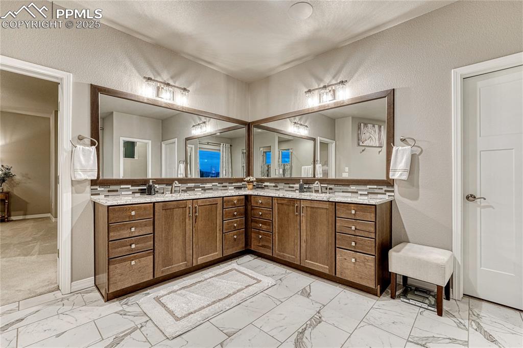 Image 22 of 48: Primary ensuite with dual vanities and a walk-in closet 