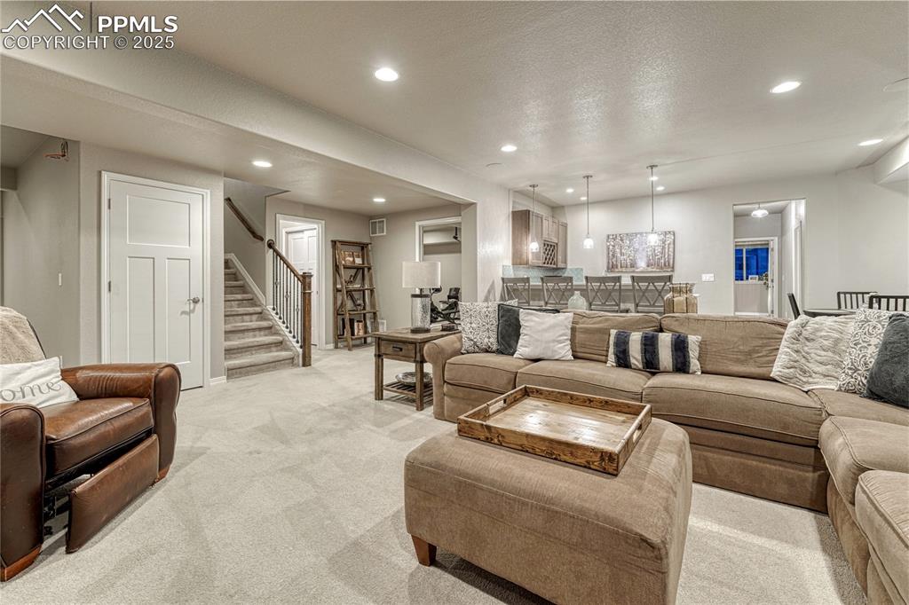 Image 29 of 48: Large, open family room with a wet bar and adjacent game area. 
