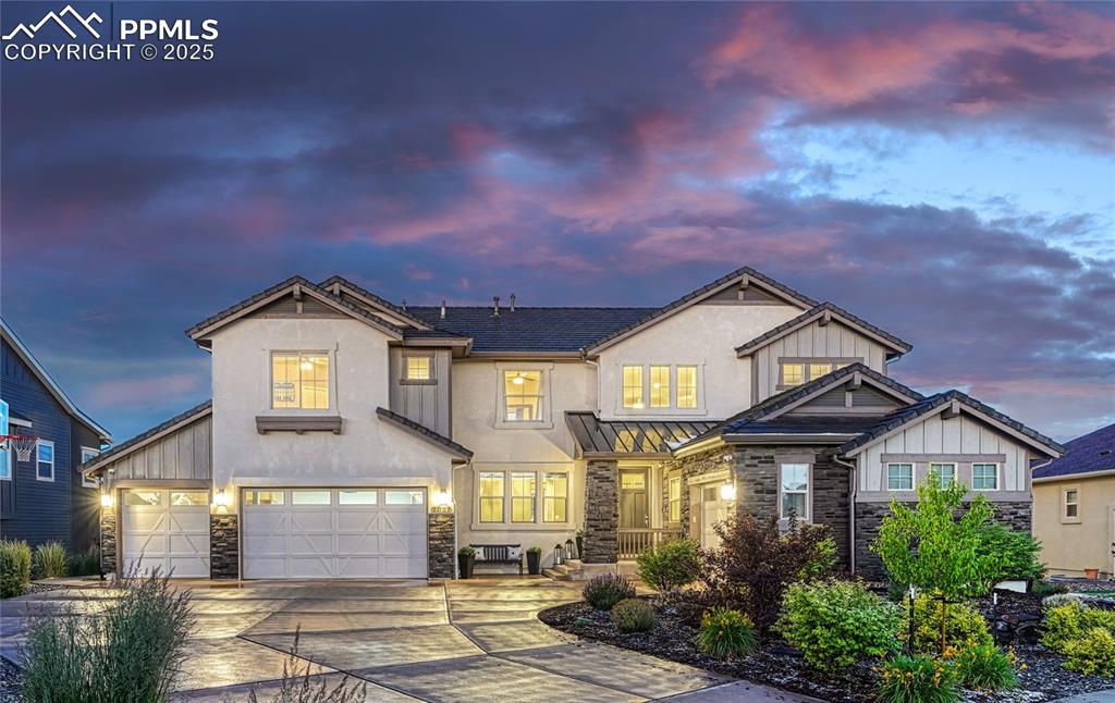Image 42 of 48: View of front of house with stone and stucco siding, a 4-car garage, and a 