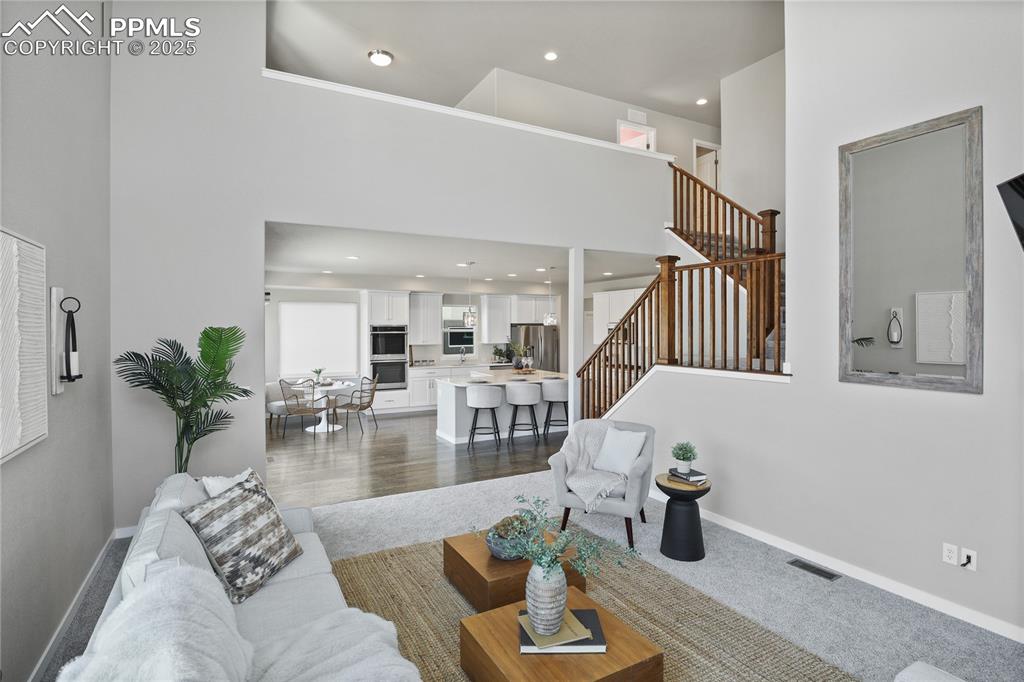 Image 17 of 50: Living area featuring stairway, recessed lighting, baseboards, and a toweri