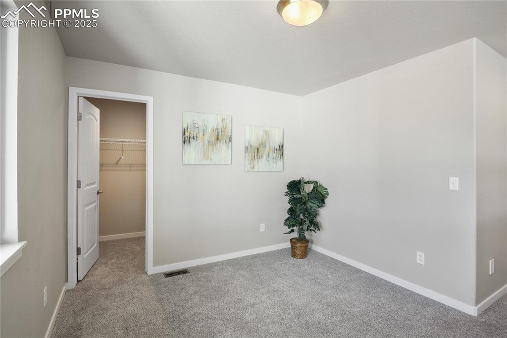 Image 21 of 50: Unfurnished bedroom featuring carpet floors, baseboards, and a spacious clo