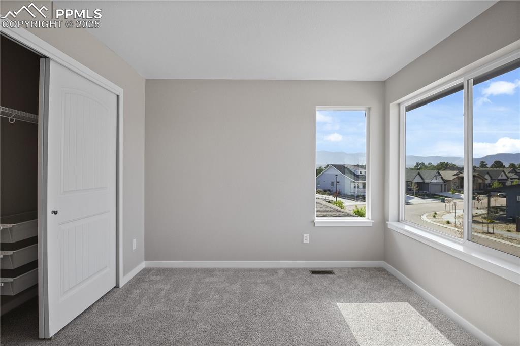 Image 24 of 50: Unfurnished bedroom featuring carpet flooring, baseboards, a closet, a resi