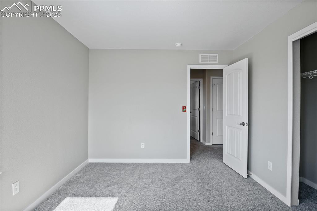 Image 25 of 50: Unfurnished bedroom with carpet flooring and baseboards