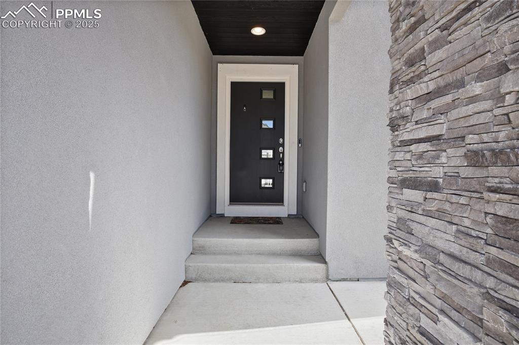 Image 3 of 50: Property entrance with stucco siding
