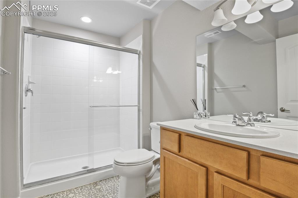 Image 41 of 50: Full bathroom featuring a shower stall, toilet, vanity, and recessed lighti