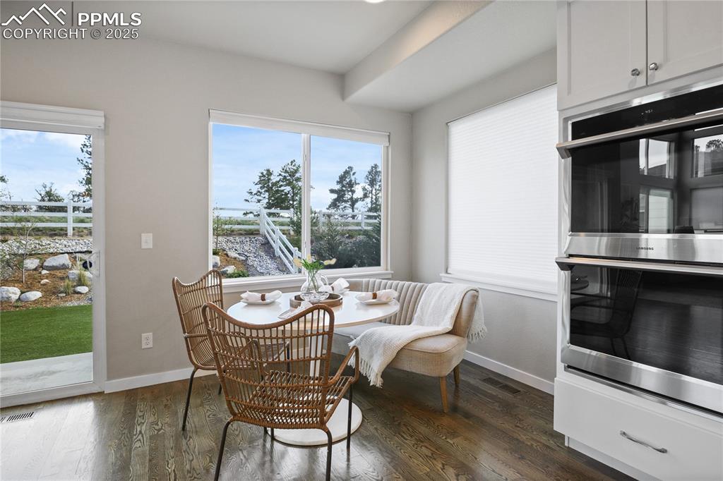 Image 7 of 50: Dining area featuring dark wood-style floors, baseboards, and healthy amoun