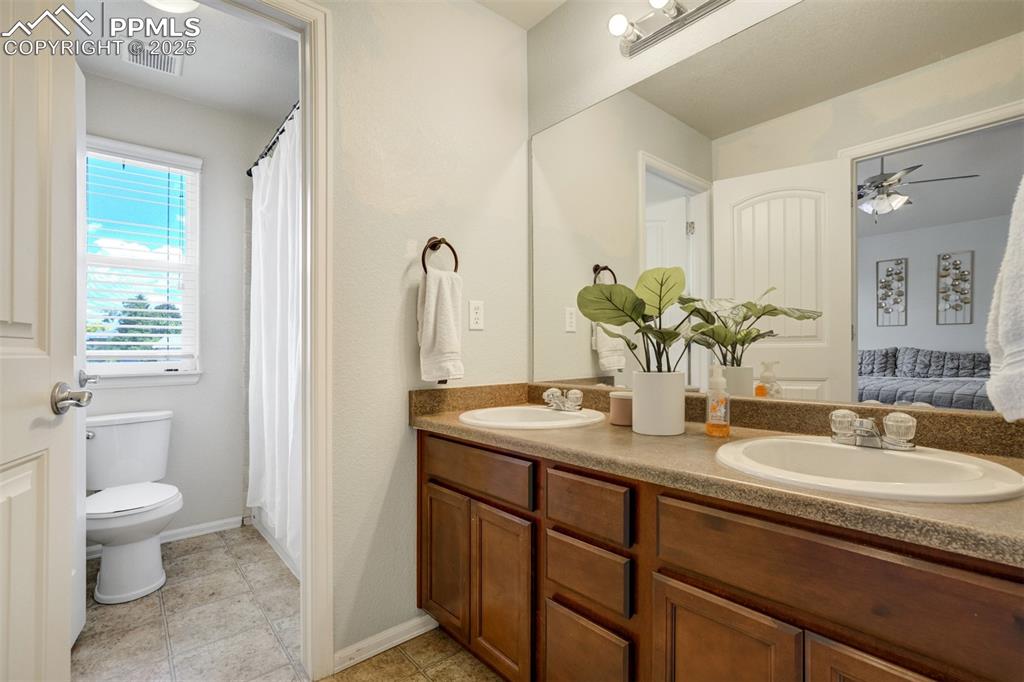 Image 17 of 28: Attached bathroom with dual vanities & tub/shower. 