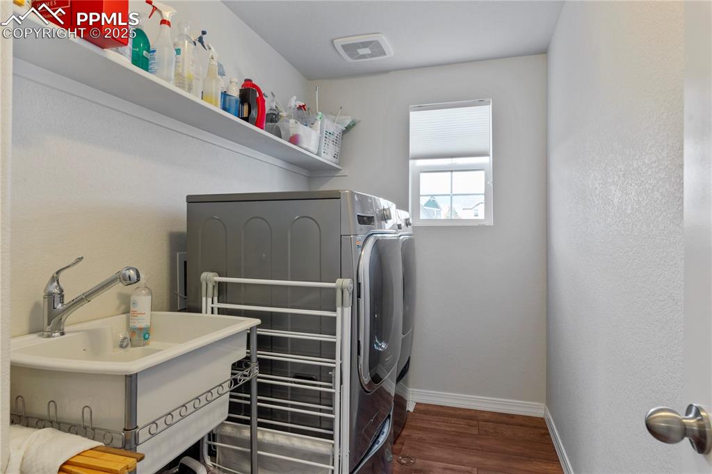 Image 22 of 38: Upstairs laundry with sink and window