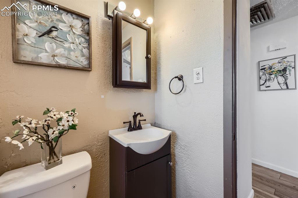 Image 14 of 28: Bathroom with hardwood / wood-style flooring, vanity, and toilet
