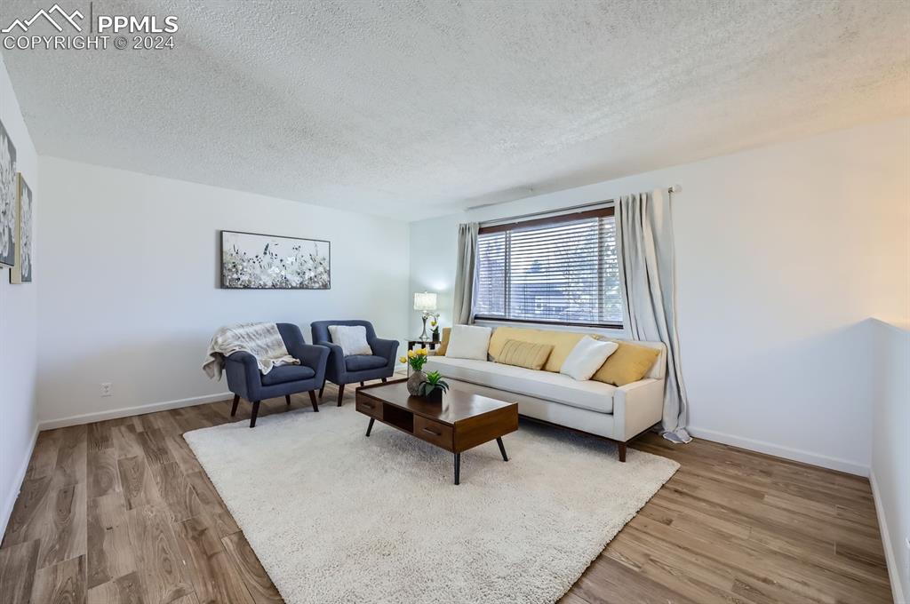Image 4 of 28: Living room with a textured ceiling and hardwood / wood-style flooring