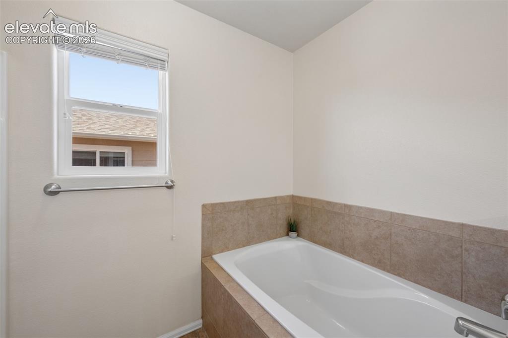 Image 13 of 33: Primary Bedroom En-suite Soaking Tub and Stand Alone Shower