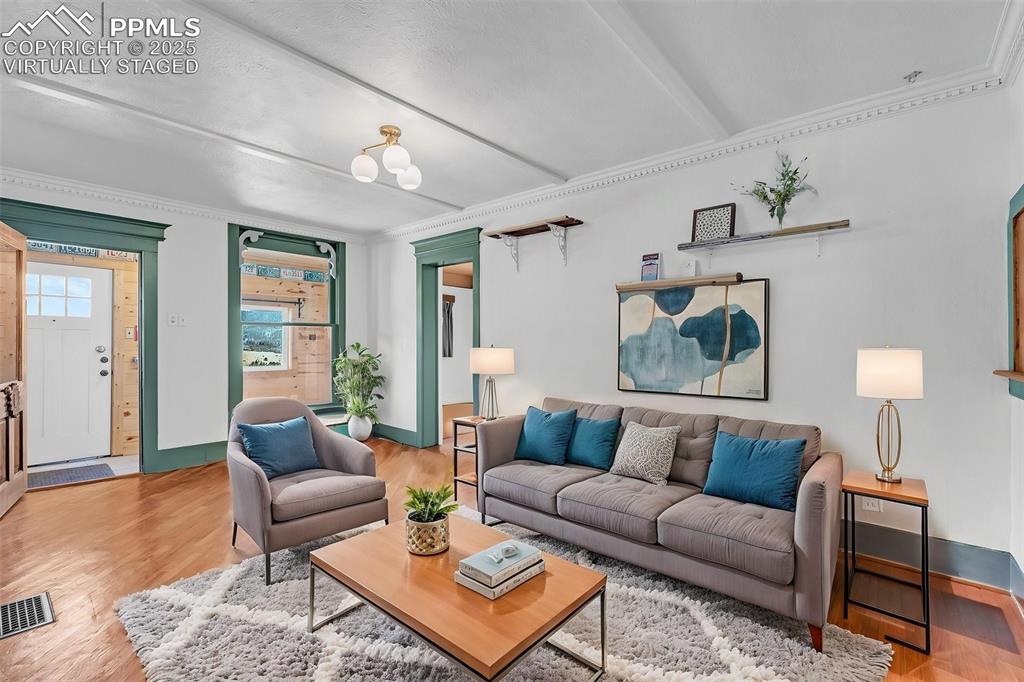 Image 11 of 50: Virtually Staged Living room with wood floors, crown molding