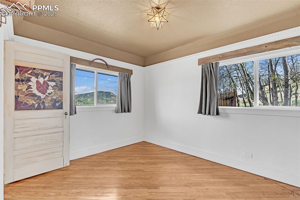 Image 12 of 50: Main bedroom off the entry hallway and living room featuring wood floors