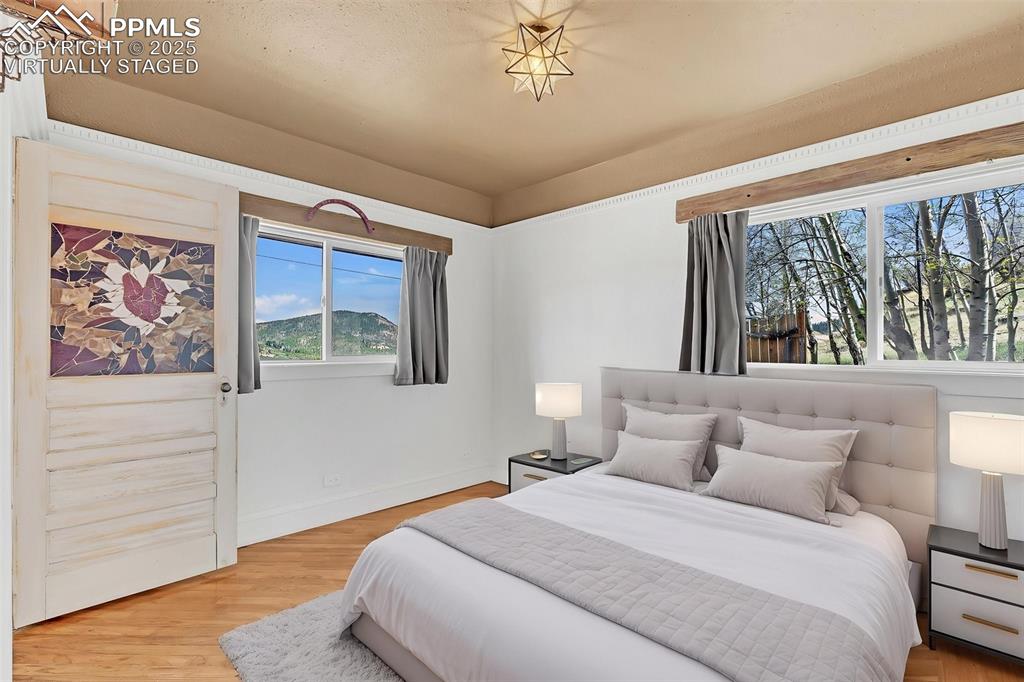 Image 13 of 50: Virtually Staged main bedroom off living room and front hallway with entry