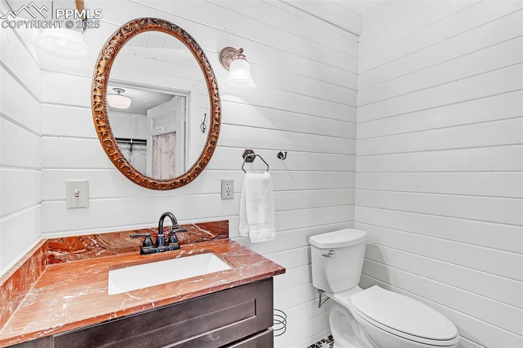 Image 20 of 50: Bathroom with toilet and vanity and shower off the main bedroom. Mirror op
