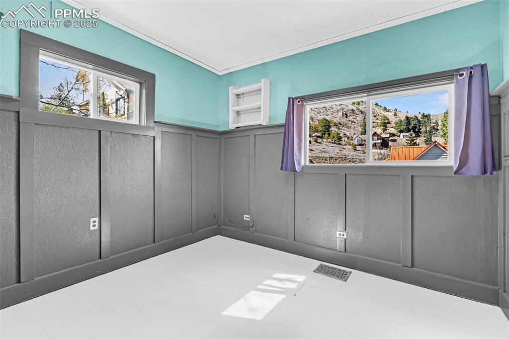 Image 24 of 50: Bedroom featuring a decorative wall and wainscoting