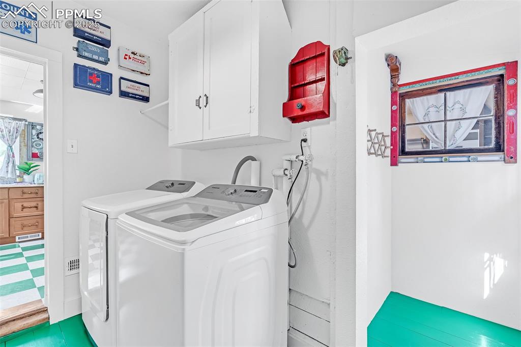 Image 40 of 50: Laundry with cabinet space and washer and clothes dryer provides access to