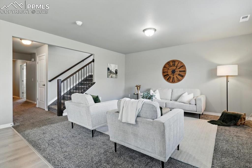 Image 10 of 45: Living room featuring stairs and light wood-style flooring