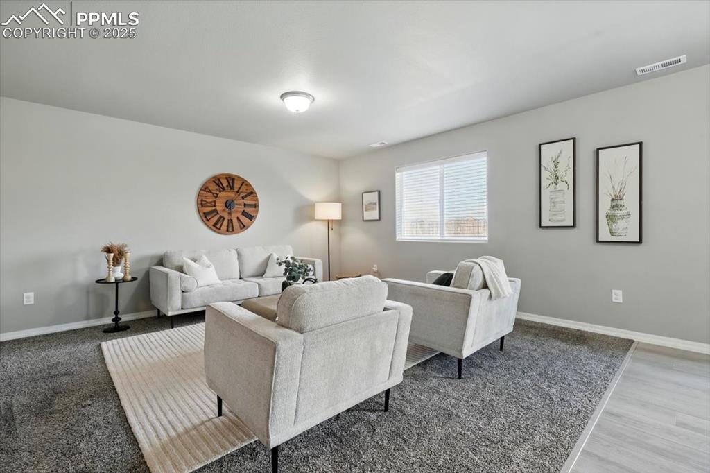 Image 12 of 45: Living area with baseboards and wood finished floors