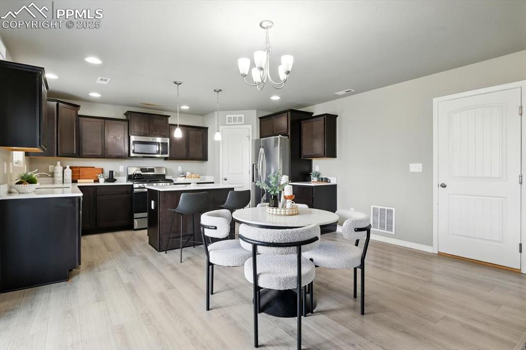 Image 15 of 45: Dining space featuring light wood-style flooring, a chandelier, and recesse