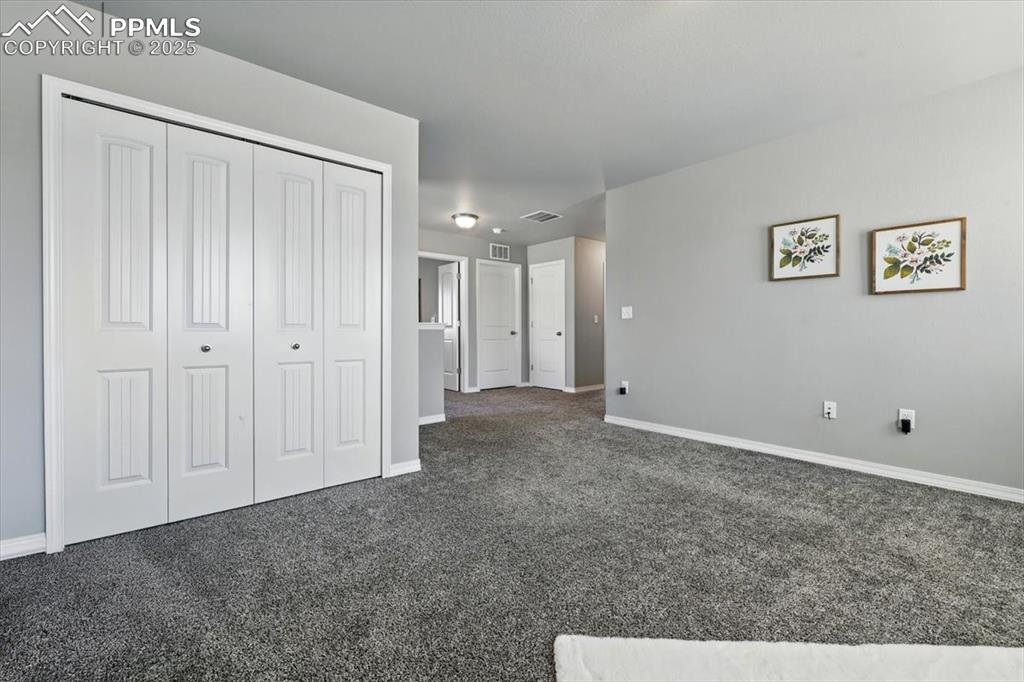 Image 23 of 45: Unfurnished bedroom with dark colored carpet and a closet