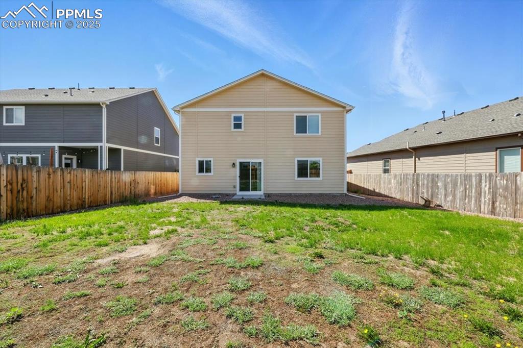Image 38 of 45: Back of house with a fenced backyard