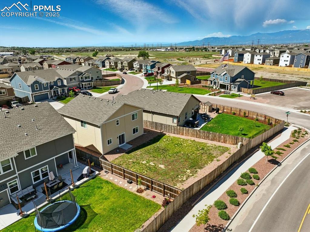 Image 42 of 45: Aerial view of residential area featuring a mountain backdrop