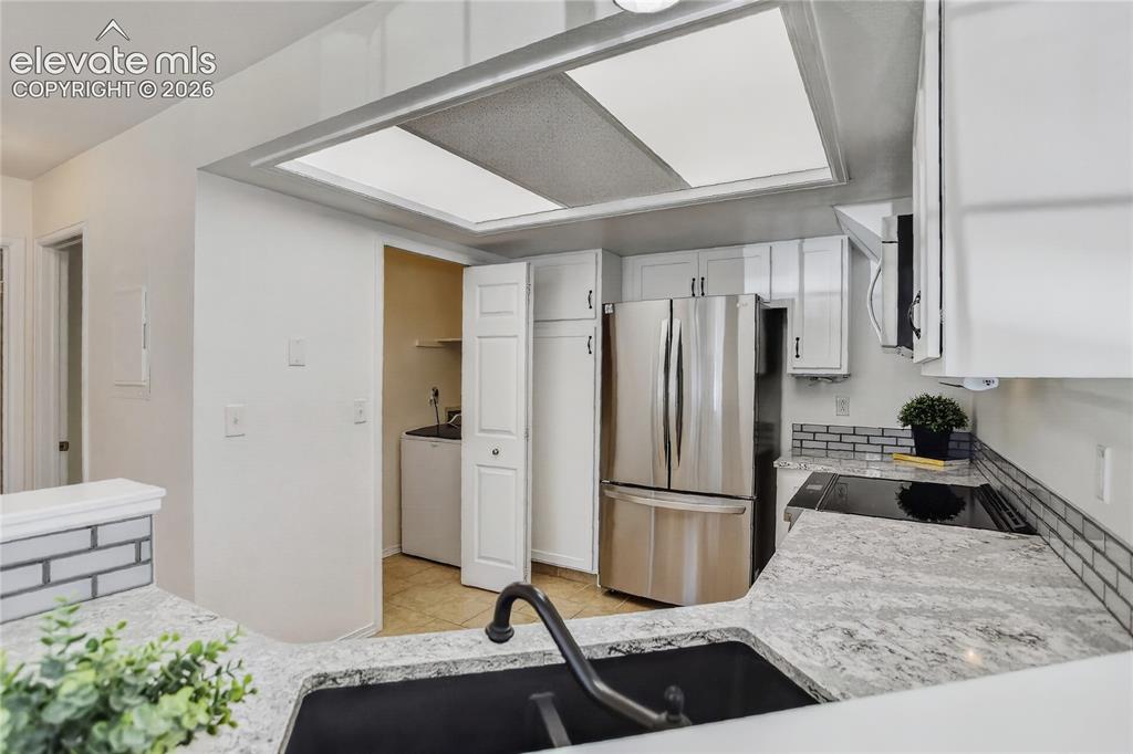 Image 6 of 16: Stone counters & tile backsplash