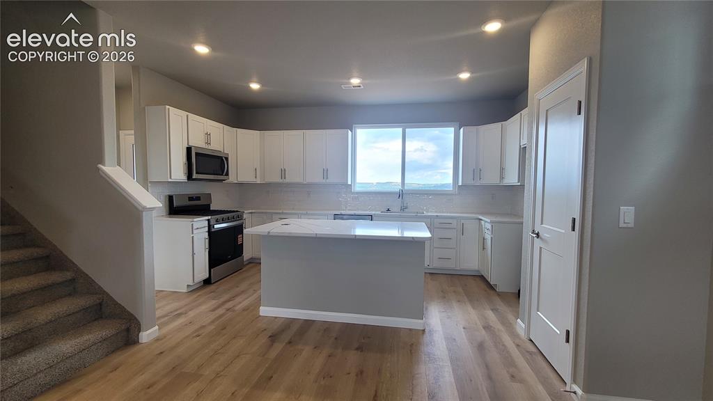 Image 12 of 32: Grand Kitchen with quartz countertops, plenty of cabinets, pantry, island p