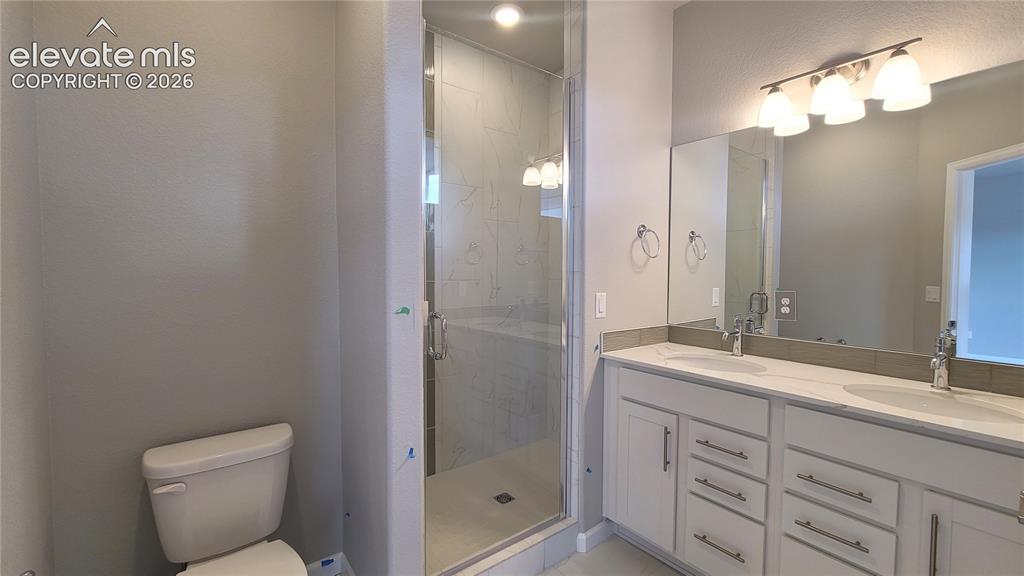 Image 26 of 32: Primary bathroom with quartz countertop, dual vanities, and tile surrounds!