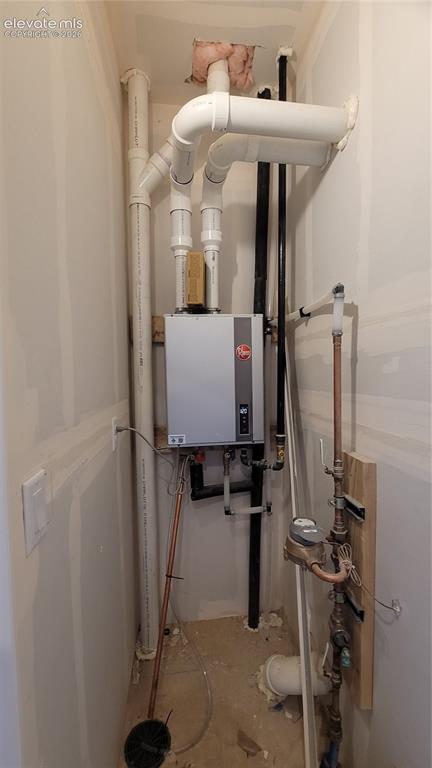 Image 30 of 32: Utility closet at entry level with a tankless water heater!