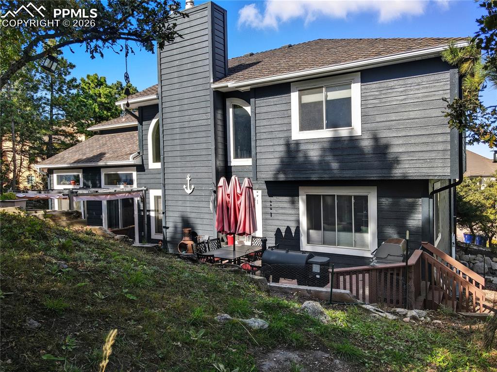 Image 10 of 45: Back of property with a chimney and a deck