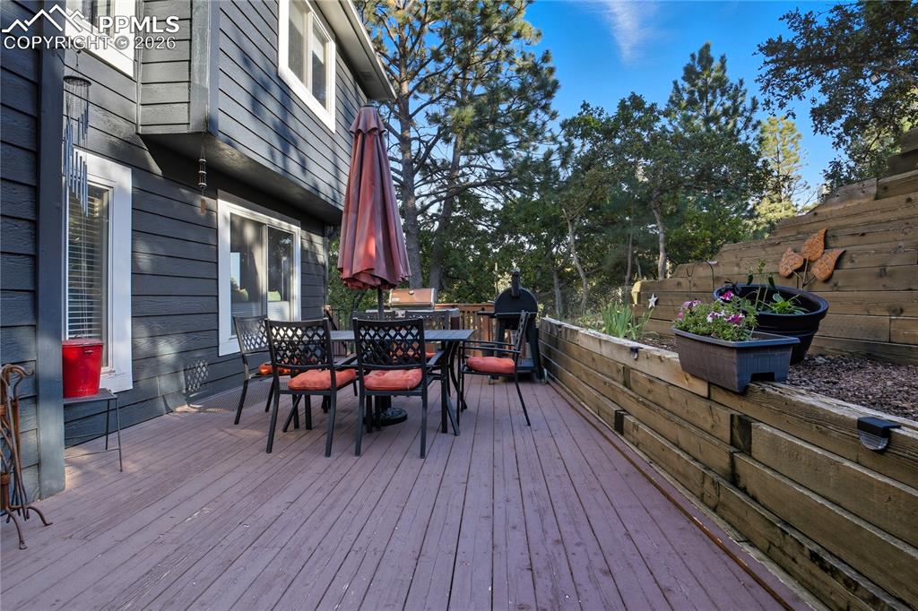 Image 11 of 45: Wooden deck featuring outdoor dining area and grilling area