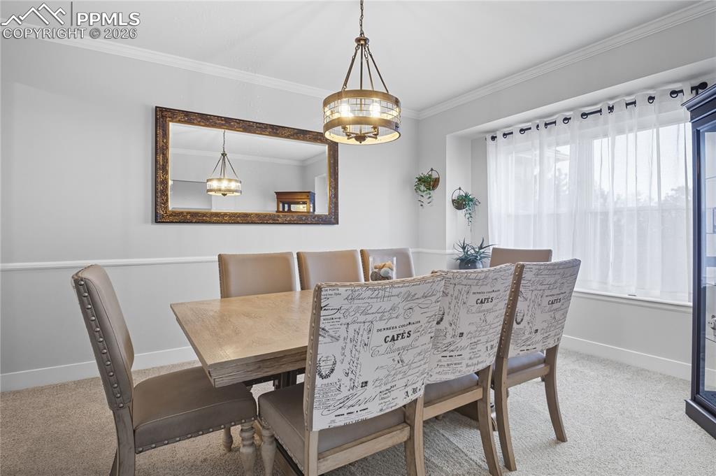 Image 15 of 45: Dining area featuring light colored carpet and crown molding