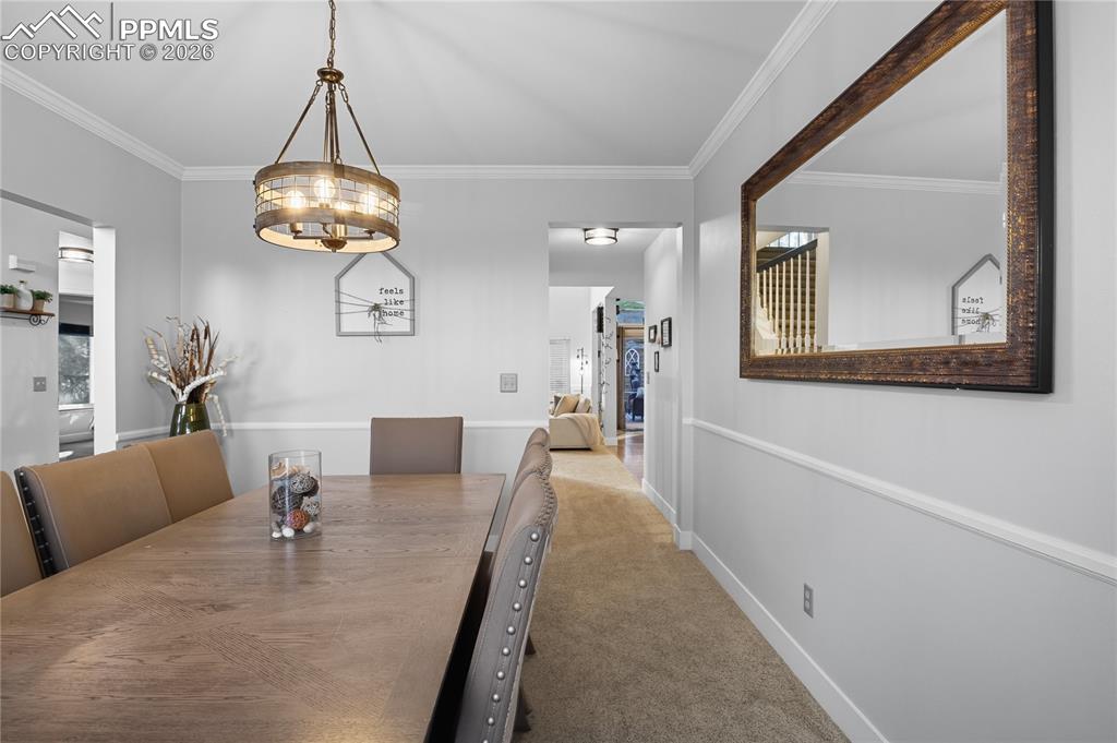 Image 16 of 45: Carpeted dining area with ornamental molding