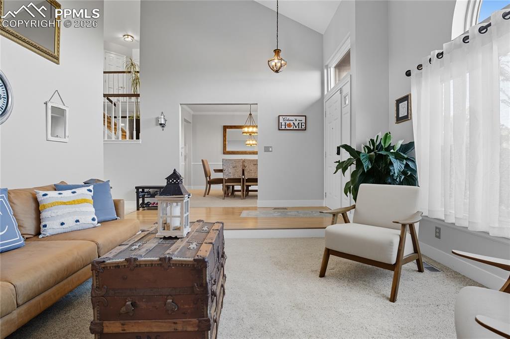 Image 18 of 45: Living area featuring carpet flooring and vaulted ceiling