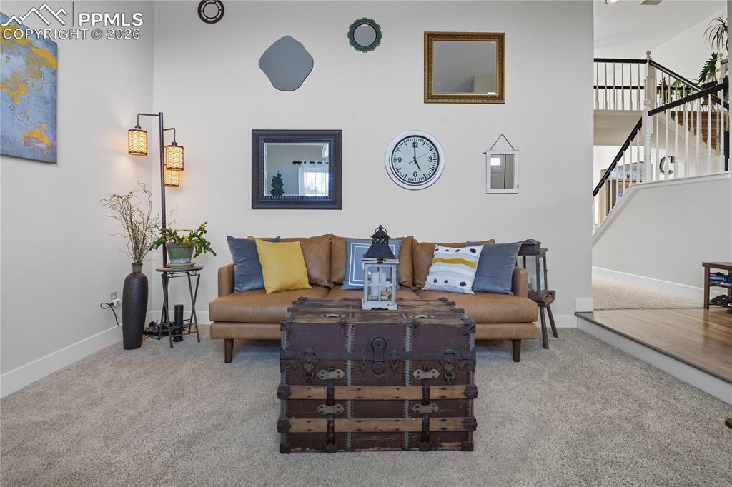 Image 19 of 45: Living area with stairs and carpet floors