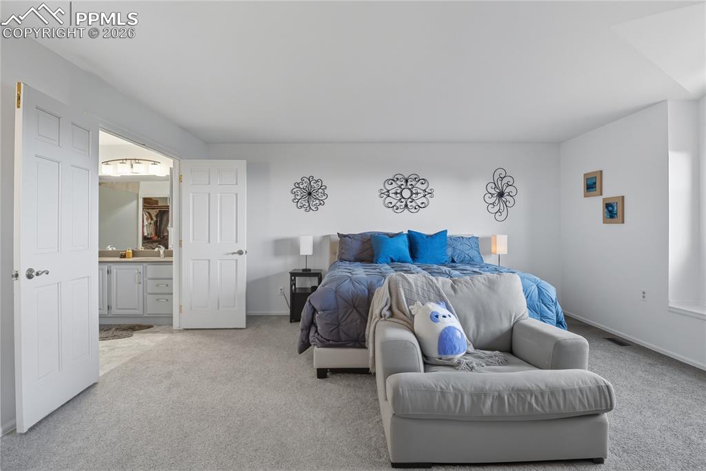 Image 25 of 45: Bedroom featuring light carpet and connected bathroom