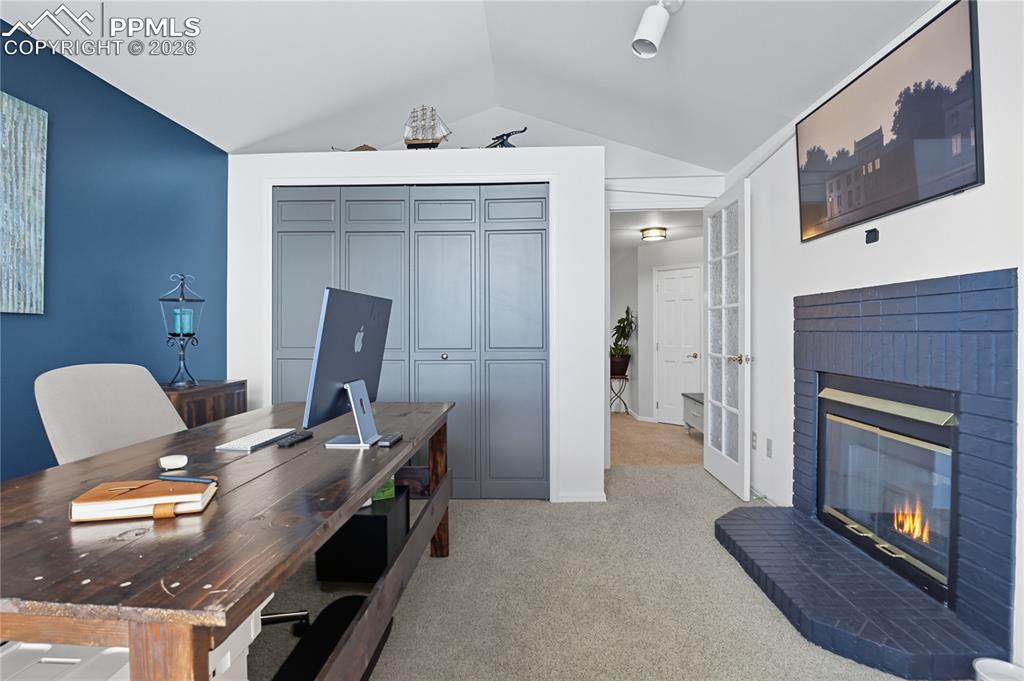 Image 30 of 45: Home office featuring a fireplace and light carpet