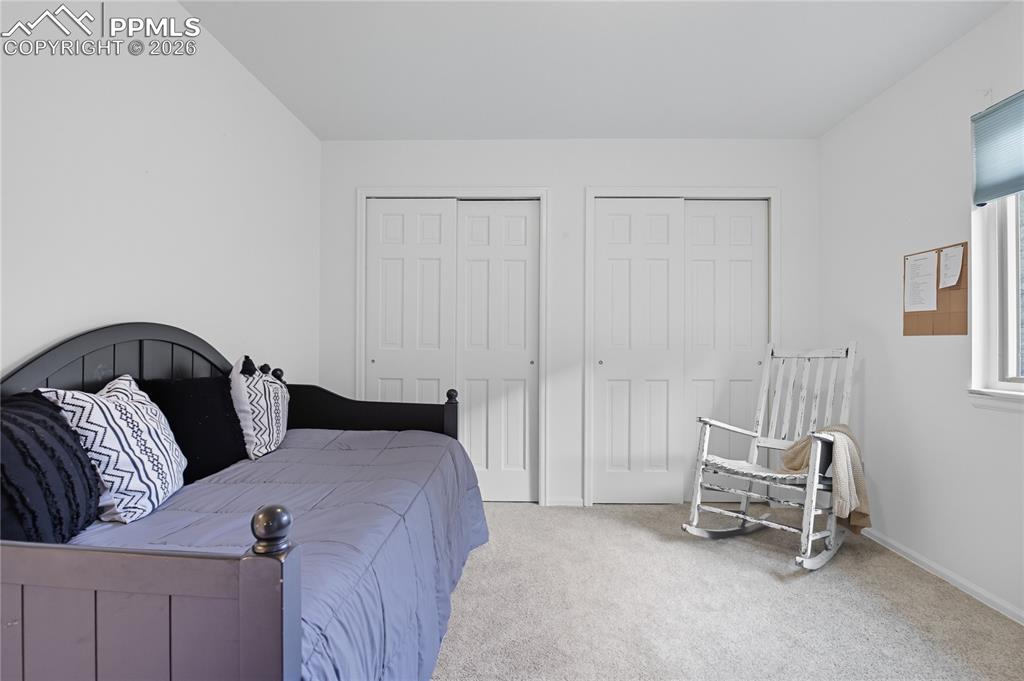 Image 33 of 45: Bedroom featuring multiple closets and light colored carpet