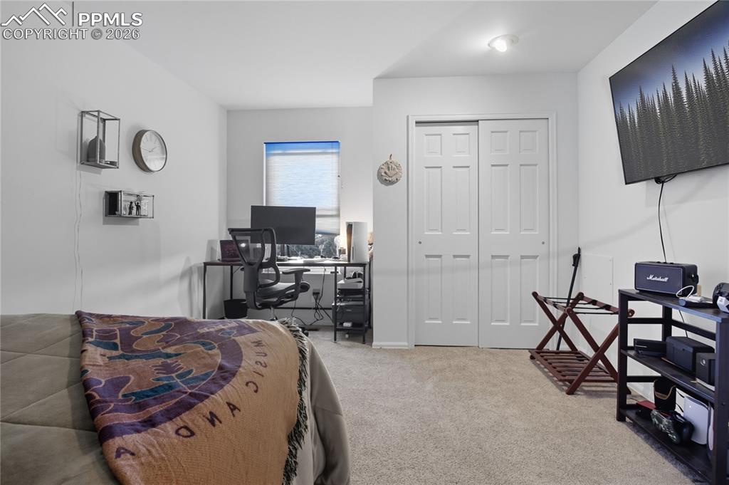 Image 36 of 45: Bedroom featuring a desk, light colored carpet, and a closet