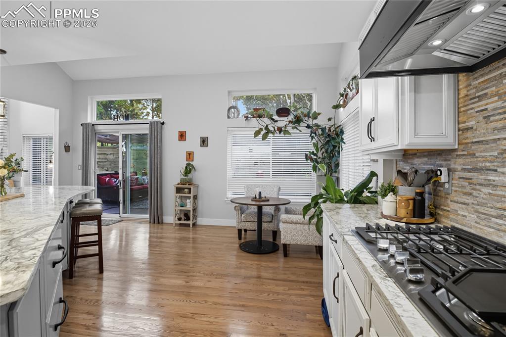 Image 8 of 45: Kitchen with stainless steel gas cooktop, a breakfast bar area, tasteful ba