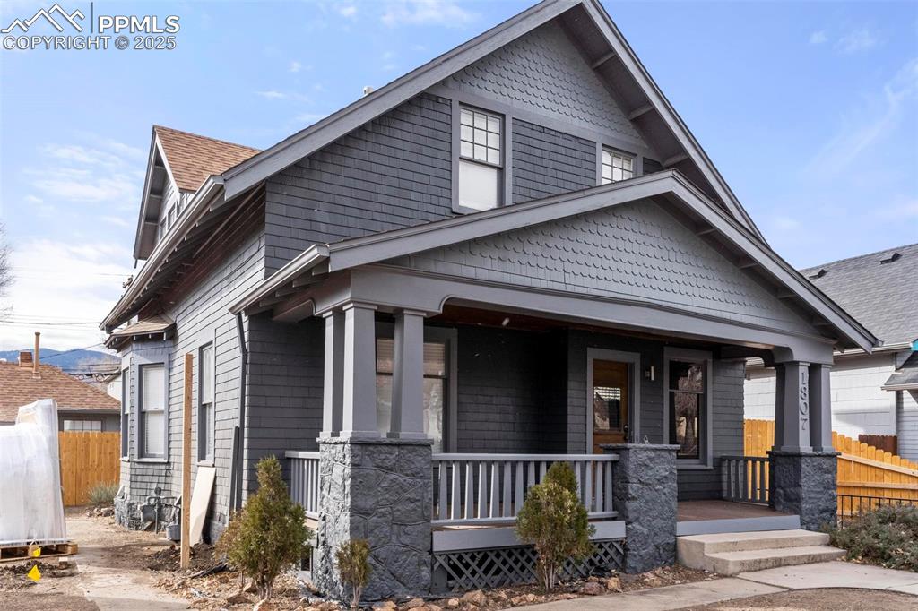 Caption: View of front of house featuring a porch and roof with shingles